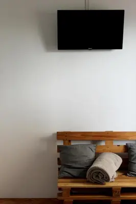 a flat screen tv on a wall with pillows at Silva's Guest House in Vila Nova de Gaia