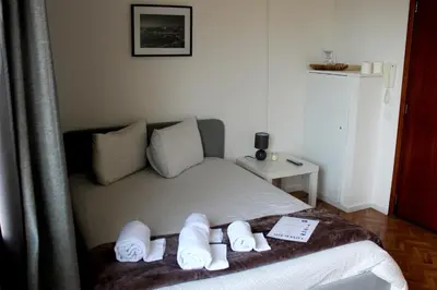 a bedroom with a bed with towels on it at Silva's Guest House in Vila Nova de Gaia