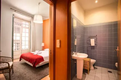 a bedroom with a bed and a bathroom with a sink at Porto by the River 1 in Porto