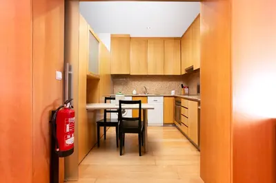 a kitchen with a table and chairs and a fire extinguisher at Porto by the River 1 in Porto