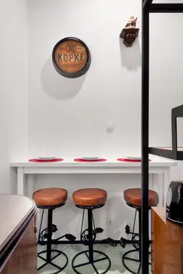 a counter with three bar stools in a kitchen at Porto National Theatre Trendy Houses in Porto