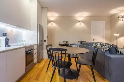 a kitchen and a living room with a table and chairs at Tailor's Apartment in Porto