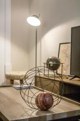 a metal sculpture on a table with a lamp at Tailor's Apartment in Porto