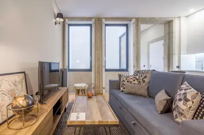 a living room with a couch and a tv at Tailor's Apartment in Porto