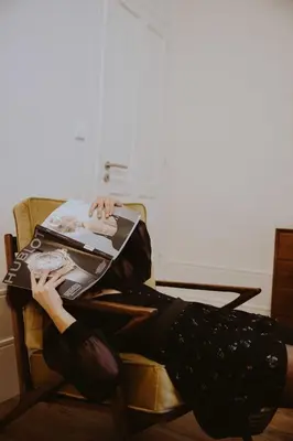 a woman sitting in a chair with her feet on a magazine at aDuquesa - GuestHouse in Porto