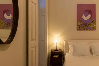 a bedroom with a bed and a picture of a man at aDuquesa - GuestHouse in Porto