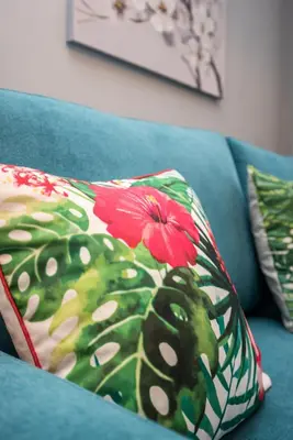 a blue couch with a pillow with flowers on it at Metropolitan Gaia-Porto in Vila Nova de Gaia