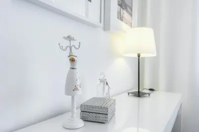 a white room with a lamp and a dresser at Metropolitan Gaia-Porto in Vila Nova de Gaia