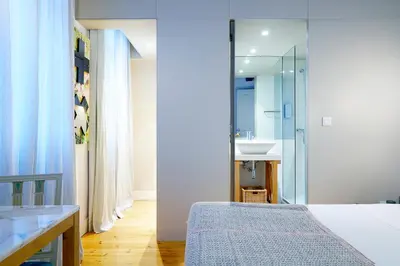a bedroom with a bed and a bathroom with a sink at The Art Porto - Holiday Homes in Porto