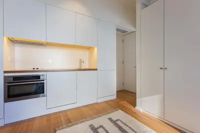 a kitchen with white cabinets and a rug on the floor at The Art Porto - Holiday Homes in Porto