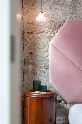 a wooden table in a room with a pink wall at The Art Porto - Holiday Homes in Porto