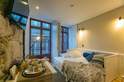 a bedroom with a bed and some windows at Oldtown Studio in Porto
