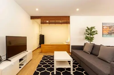 a living room with a couch and a tv at Eiffel Porto in Porto