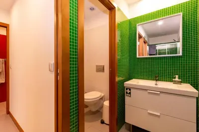 a green bathroom with a sink and a toilet at Eiffel Porto in Porto