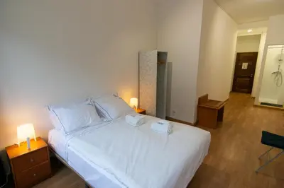 a bedroom with a white bed with two towels on it at Change The World Hostels - Porto - Santa Catarina in Porto