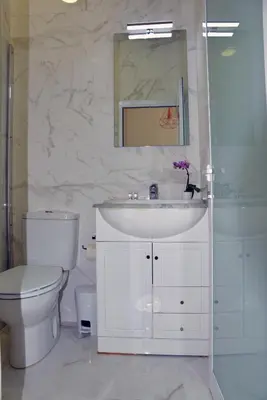 a bathroom with a sink and a toilet and a mirror at Hotel Visconde in Porto