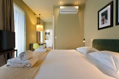 a bedroom with a large white bed with towels on it at RVA - Porto Central Flats in Porto