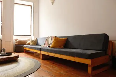 a living room with a black couch in a room at Alegria 1º in Porto