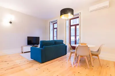 a living room with a blue couch and a table at ON Apartments - Coliseu in Porto