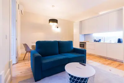 a living room with a blue couch and a table at ON Apartments - Coliseu in Porto