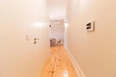 a hallway with a white door and a wooden floor at ON Apartments - Coliseu in Porto