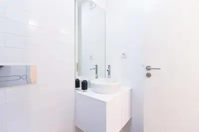 a white bathroom with a sink and a mirror at ON Apartments - Coliseu in Porto