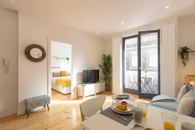 a living room with a blue couch and a bedroom at Sweet Flat 4Two in City Center, Balcony & Air Conditioning in Porto