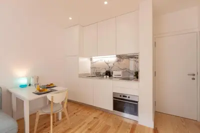 a kitchen with white cabinets and a small table at Sweet Flat 4Two in City Center, Balcony & Air Conditioning in Porto