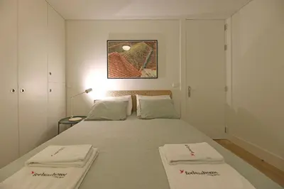 a bedroom with a bed with two white towels on it at FLH Porto Spacious Duplex in Porto