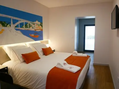 a bedroom with two beds with orange and white at Serra do Pilar Porto Suites in Vila Nova de Gaia