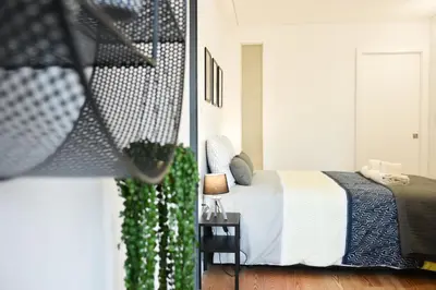 a bedroom with a bed and a table with a lamp at Comfortable&Central w/balcony-9 min walk Trindade in Porto