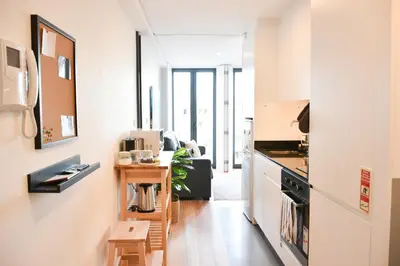 a kitchen with white walls and a table in a room at Comfortable&Central w/balcony-9 min walk Trindade in Porto