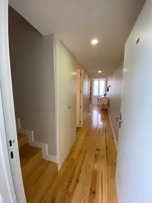 an empty hallway with a hardwood floor and an open door at Vitoria's Terrace Apartments in Porto