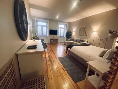 a bedroom with a bed and a living room at Vitoria's Terrace Apartments in Porto