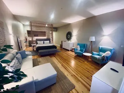 a living room with a bed and blue chairs at Vitoria's Terrace Apartments in Porto