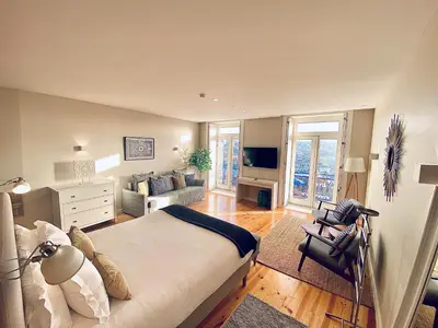 a bedroom with a large bed and a living room at Vitoria's Terrace Apartments in Porto