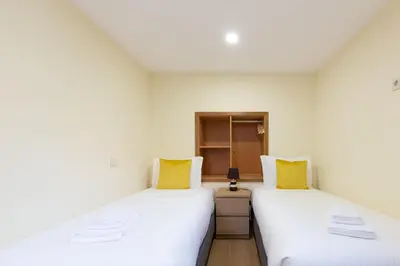 two beds in a room with white walls and yellow pillows at Yellow Tiles by PCALE in Porto
