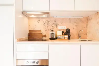 a kitchen with white cabinets and a counter top at Clérigos 168 in Porto