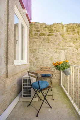 a balcony with two chairs and a table and a window at Clérigos 168 in Porto