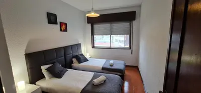 a small room with two beds and a window at Tower Records Apartment in Porto