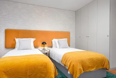 a bedroom with two beds with yellow blankets at Stylish apartment at Bolhao in Porto