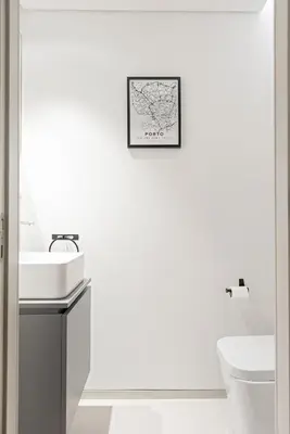 a white bathroom with a sink and a map on the wall at Stylish apartment at Bolhao in Porto