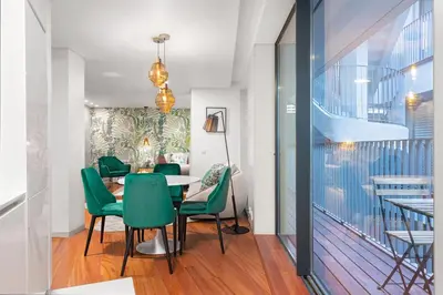 a dining room with a table and green chairs at Stylish apartment at Bolhao in Porto