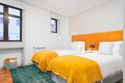 a bedroom with two beds with yellow blankets at Stylish apartment at Bolhao in Porto