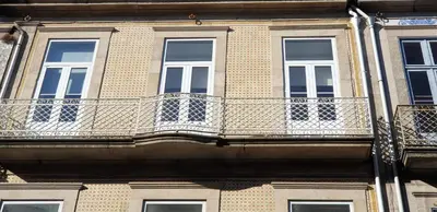 a building with a balcony on the side of it at House, view of Bolhão market in Porto