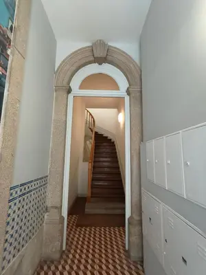 a hallway with an archway and stairs in a building at House, view of Bolhão market in Porto