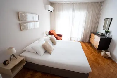 a bedroom with a large white bed and a window at Alegria Cozy com Terraço - Centro do Porto in Porto