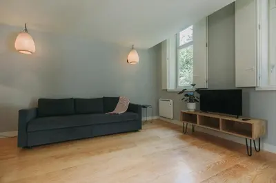 a living room with a couch and a tv at Oporto Maison Palace in Porto