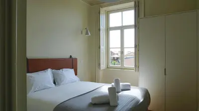 a bedroom with a bed with two towels on it at Oporto Maison Palace in Porto