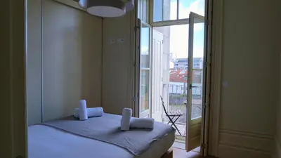 a bedroom with a bed and a large window at Oporto Maison Palace in Porto